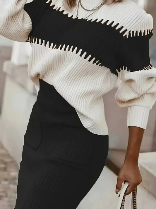 Person wearing a black and white sweater with a blurred background