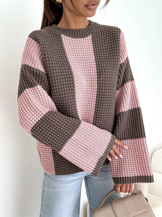 Person wearing a pink and brown striped sweater with a white background