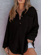 Woman wearing a black textured shirt against a neutral background