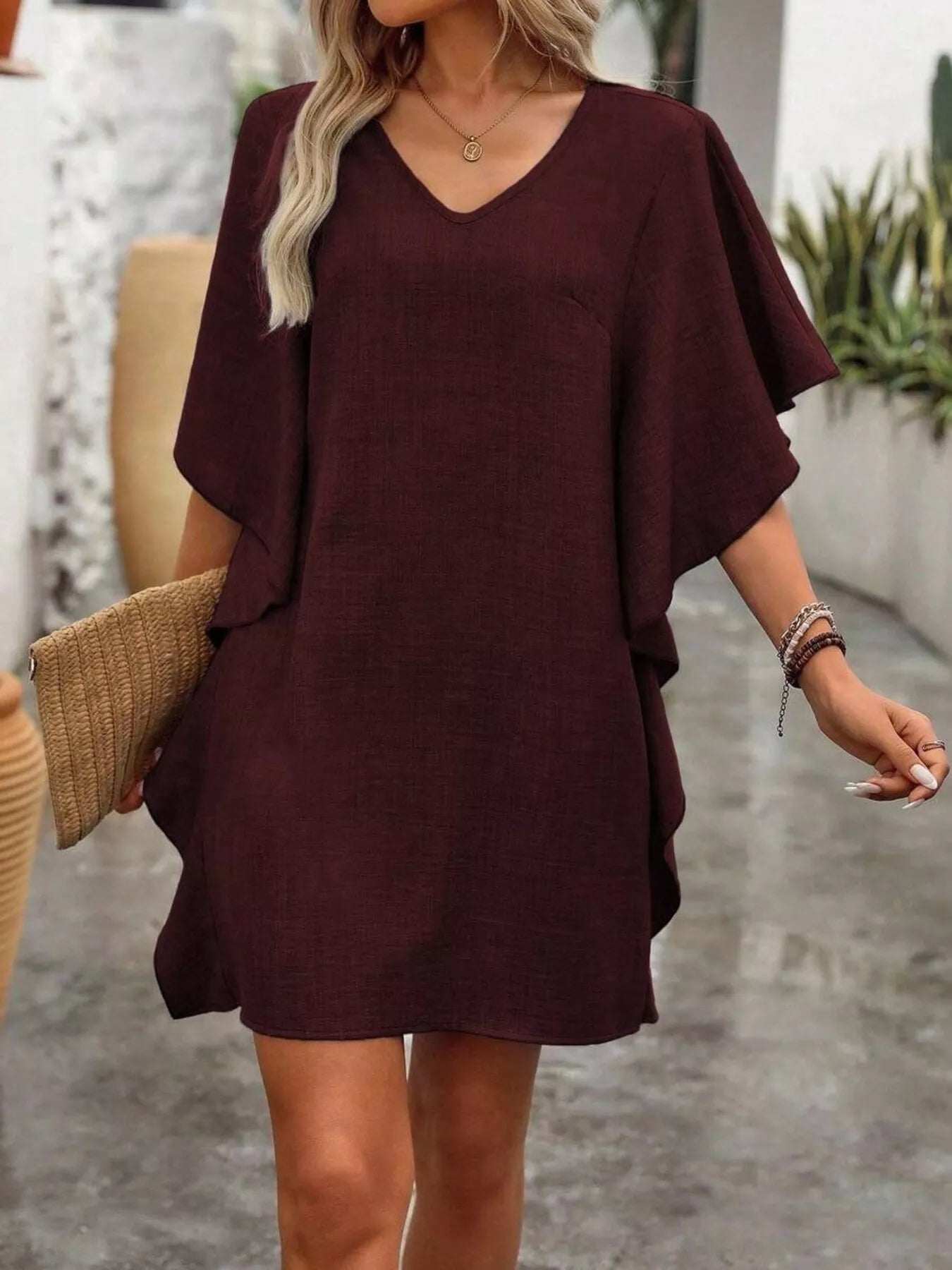 Woman wearing a burgundy dress with a neutral background