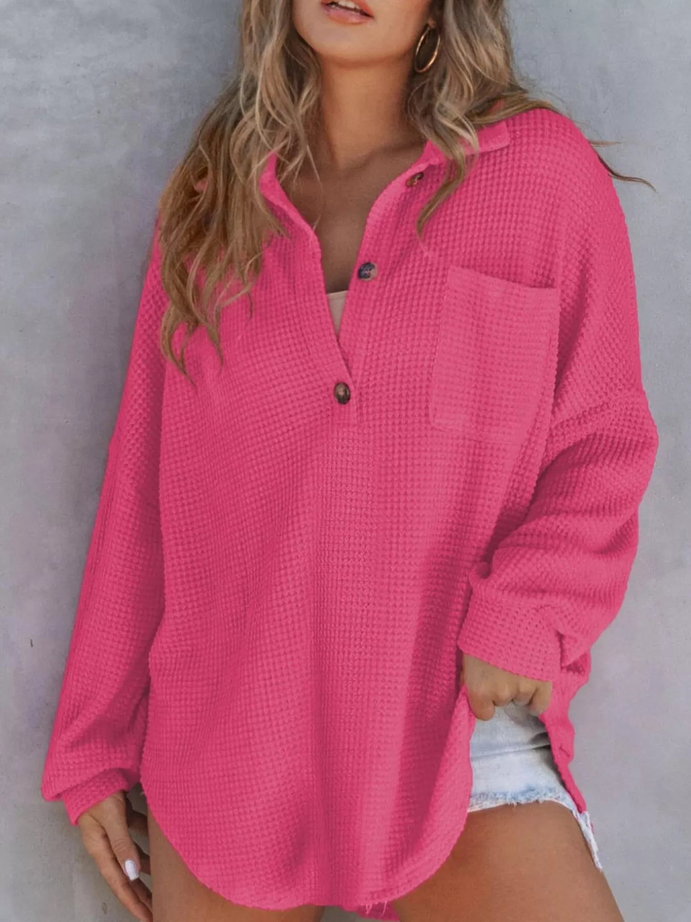 Woman wearing a pink textured shirt against a gray background
