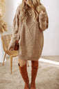 Woman wearing a tan cable knit sweater dress with brown knee-high boots in a minimalistic setting.