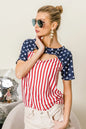 The American Flag Theme Front Cut Out Top showcases patriotic flair with its American flag theme design. The front cut-out detail adds a trendy and edgy touch to the top, showcasing the stars across the shoulders and the strips down the torso.